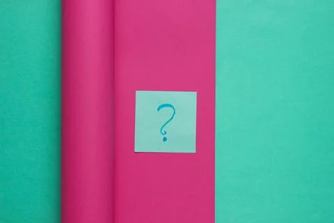 Question mark on memo piece of paper against wrapped paper background. Pastel Stock Photos