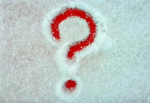 A question mark painted on a snow-covered red pedestal Stock-Fotos