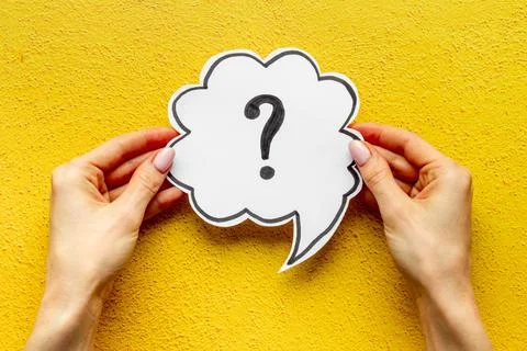 Question mark on speech bubble in hands. FAQ or search information Stock Photos