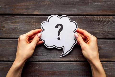 Question mark on speech bubble in hands. FAQ or search information Stock Photos