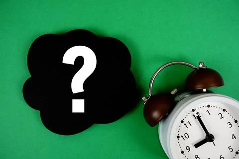 Question mark text on speech bubble with alarm clock on green background Stock Photos
