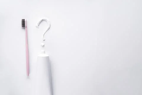 Question mark of toothpaste with a pink toothbrush on a white background. Spa Foto stock