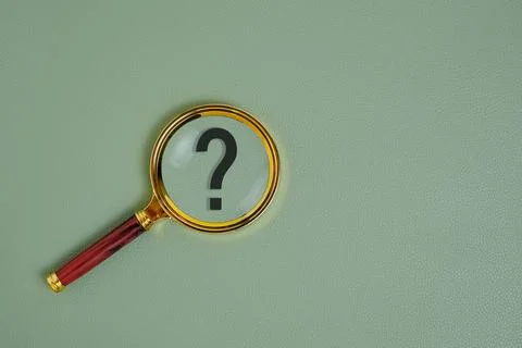 Question mark under magnifying glass, on green background. Stock Photos