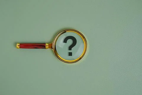 Question mark under magnifying glass, on green background. Stock Photos