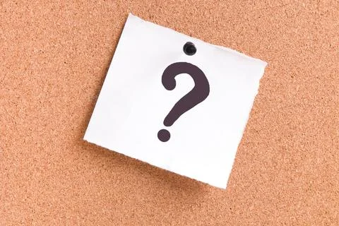 Question mark on a white sheet attached to a cork board with a pin Stock Photos