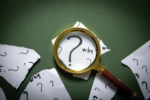 Question marks and Why? word with magnifying glass. Stock Photos