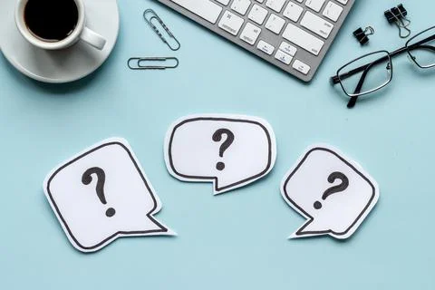 Question marks on office dest - FAQ concept. Top view Stock Photos