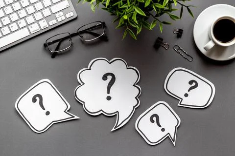 Question marks on office dest - FAQ concept. Top view Stock Photos