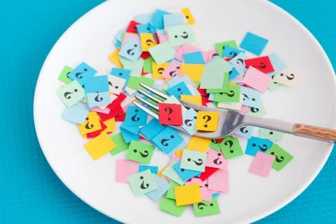Question marks on a white plate with fork Stock Photos