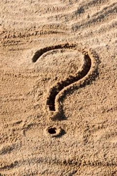 Question marks written on beach sand close up, with copy space Stock Photos
