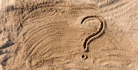 Question marks written on beach sand close up, with copy space 스톡 사진