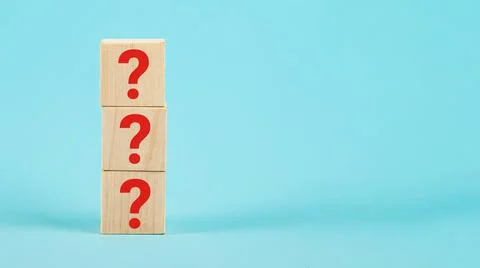 QUESTION The shape of a wooden cube block with a question mark symbol on a blue Stock Photos