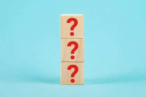 QUESTION The shape of a wooden cube block with a question mark symbol on a blue Stock Photos