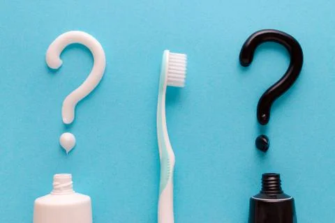 Question from white and black toothpaste, teeth care concept, toothbrush on blue Foto stock