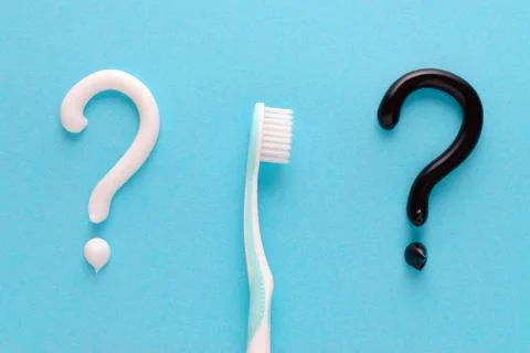 Question from white and black toothpaste, teeth care concept, toothbrush on blue Stock Photos