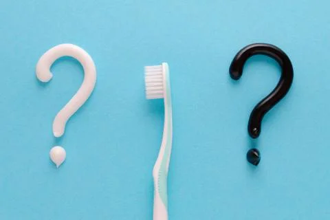 Question from white and black toothpaste, teeth care concept, toothbrush on blue Stock Photos