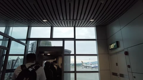 Queue to board the airplane through jet bridge Video stock 325962154