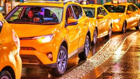 Queue of cabs waiting for customers at night in Manhattan Stock Photos