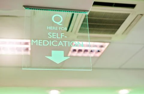 Queue here for your wellbeing. a self-medication sign in a pharmacy. Stock Photos