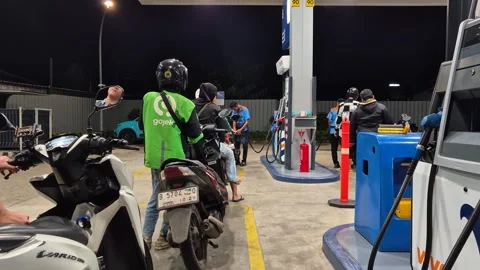 Queue of motorcyclists and a ride-hailing driver refueling at a Vivo gas st.. Stock Footage 331325172