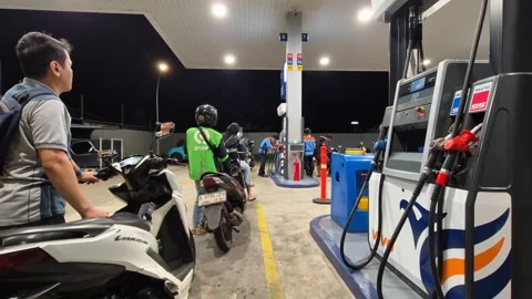 Queue of motorcyclists and a ride-hailing driver refueling at a Vivo gas st.. Stock Footage 331325178