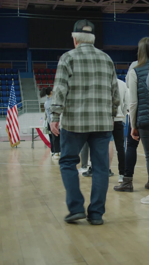 Queue of multi ethnic American citizens come to vote in polling station Stock Footage 273863532