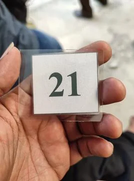 The queue number of the laminated paper in hand Stock Photos