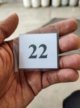 The queue number of the laminated paper in hand Stock Photos