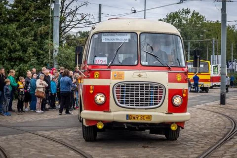 A queue of passengers getting into a vintage bus at the bus station. Stock Photos