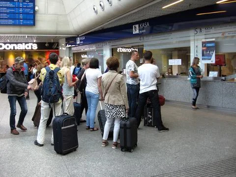 Queue of passengers standing for tickets at ticket office of railway station Stock Photos