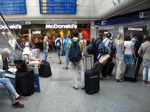Queue of passengers standing for tickets at ticket office of railway station Stock Photos