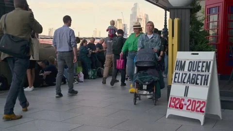 The queue to see The Queen laying in state opposite a sign Video stock 211836520