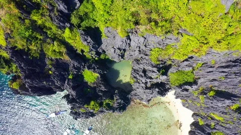 Queue of tourists comes in hidden tropical lagoon surrounded by cliffs in Stock Footage 107977801