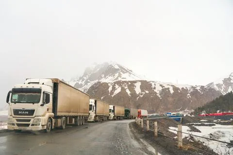 A queue of trucks in the snow-capped mountains is waiting for the pass to be  Foto stock
