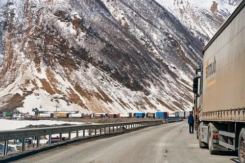 A queue of trucks in the snow-capped mountains is waiting for the pass to be  Stock Photos