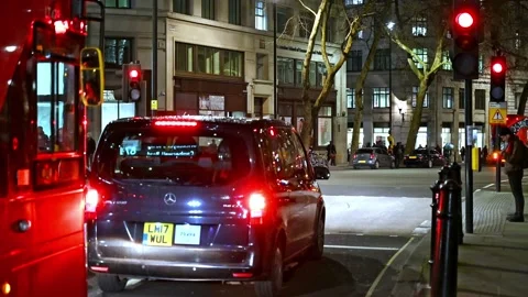Queuing traffic pulls away from a pedestrian crossing red light signal as it Video stock 131797412