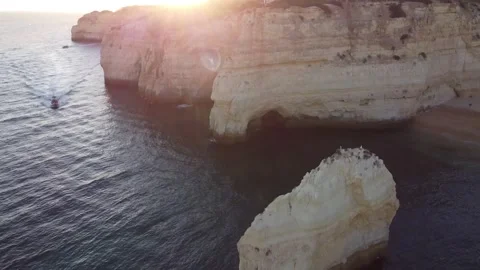 Quick Aerial Landscape Tilt Down of Sea Coast with Sun Beams Peeking Through Stock Footage 249256428