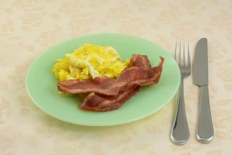 Quick breakfast of scrambled eggs and turkey bacon Stock Photos