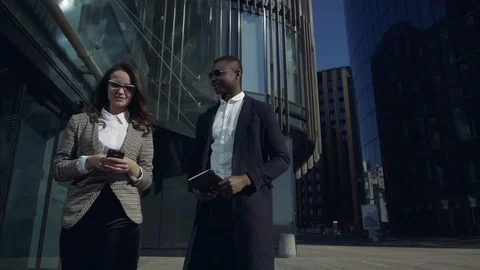 Quick briefing before meeting. Two cheerful young business people talking to Video stock 107152178