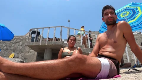 Quick camera of a couple sitting on the sand of Senoritas beach in 4k - Punta Stock Footage 195967591