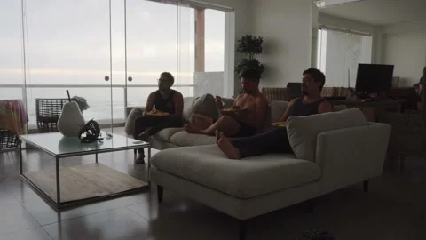 Quick camera of friends sitting in the armchair eating in the living room Video stock 192956424