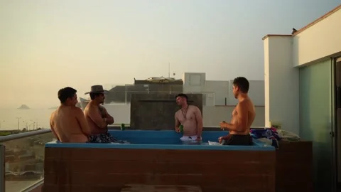 Quick camera of several friends talking and drinking in a pool on a terrace Video stock 185339470