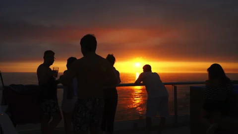 Quick camera of several male and female friends looking at a beautiful sunset Vidéo 193109703