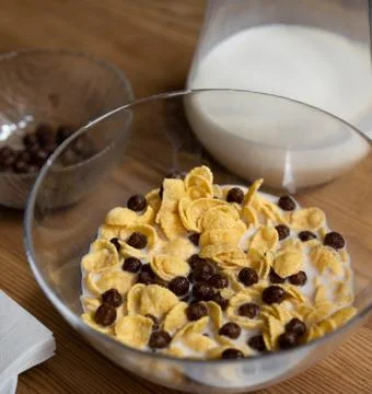 Quick cereal breakfast. Corn flakes with chocolate balls and milk in a glass Stock Photos