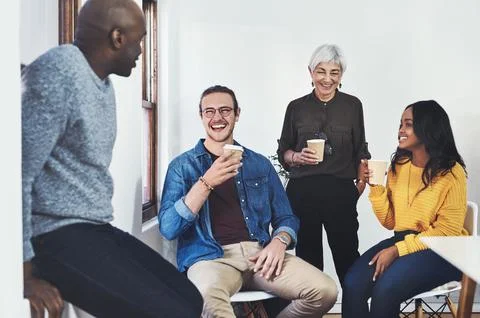 A quick coffee before we get started. a group of cheerful businesspeople having Stock Photos