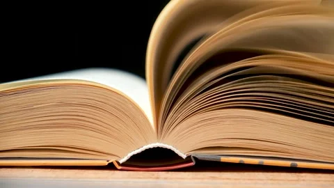 Quick flipping through a book on a black background. Knowledge and wisdom Stock Footage 265473511