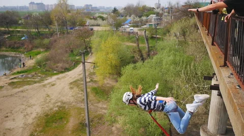 Quick jump girl from the bridge facing forward with a push from the instructor Stock Footage 68350062