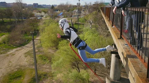 Quick jump girl from the bridge facing forward with a push from the instructor Stock Footage 68351941