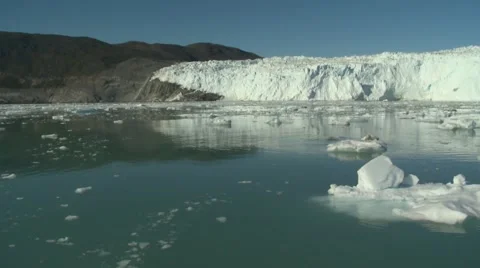 Quick pan and moving through calm icy waters at a large glacier front Video stock 60004057