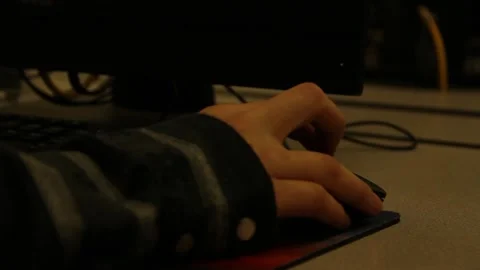Quick pan from computer screen to person's hand on mouse Stock Footage 134677323